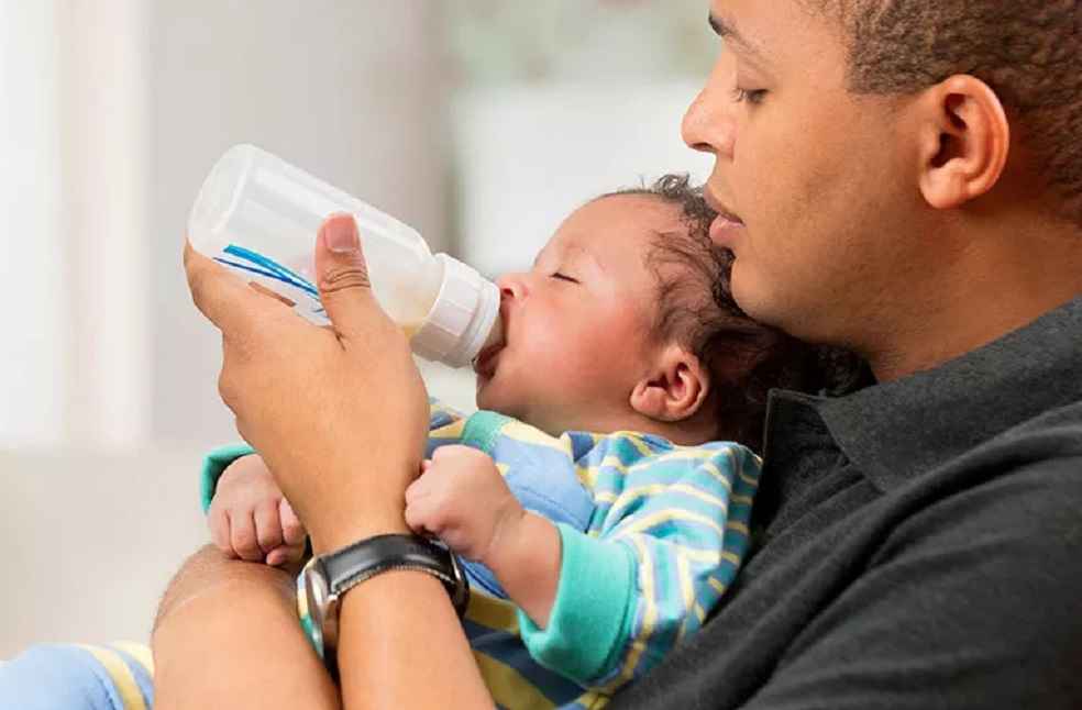 parent-feeds-baby-bottle